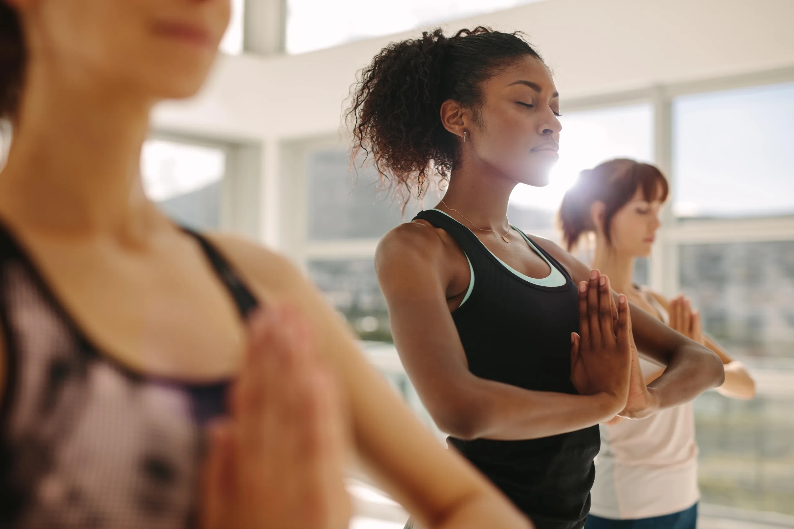 Woman in yoga studio, Zen bright warm glow of sunlight coming in from the windows.